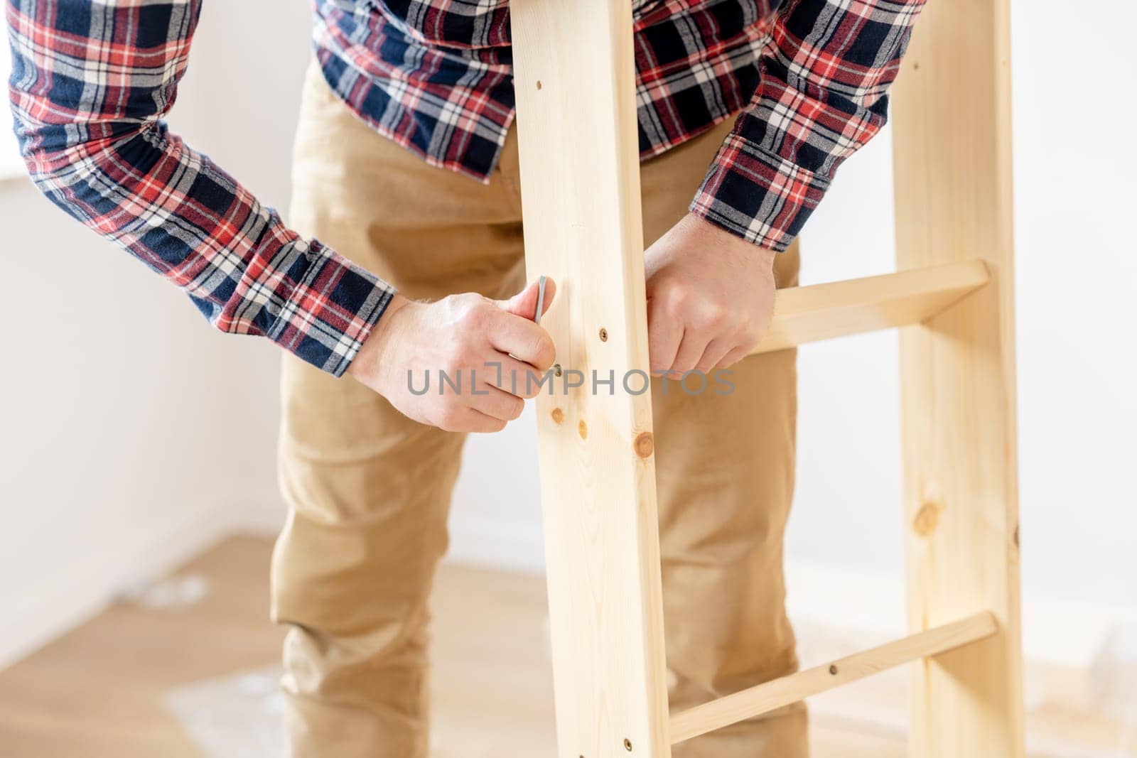 Man Assembling Bed On The Floor At Home