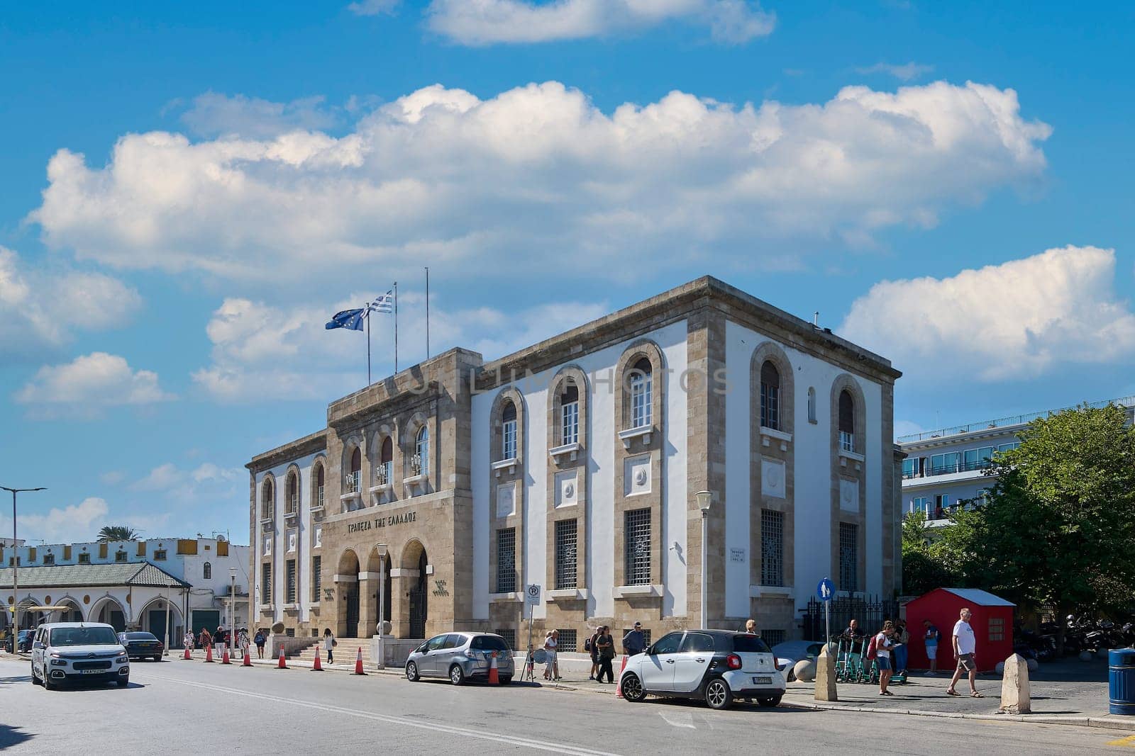 Rodas.Greece - june 05, 2025: Exterior view of the Bank of Greece, a prominent building in Rhodes city, showcasing its classical design and the daily hustle of the street.