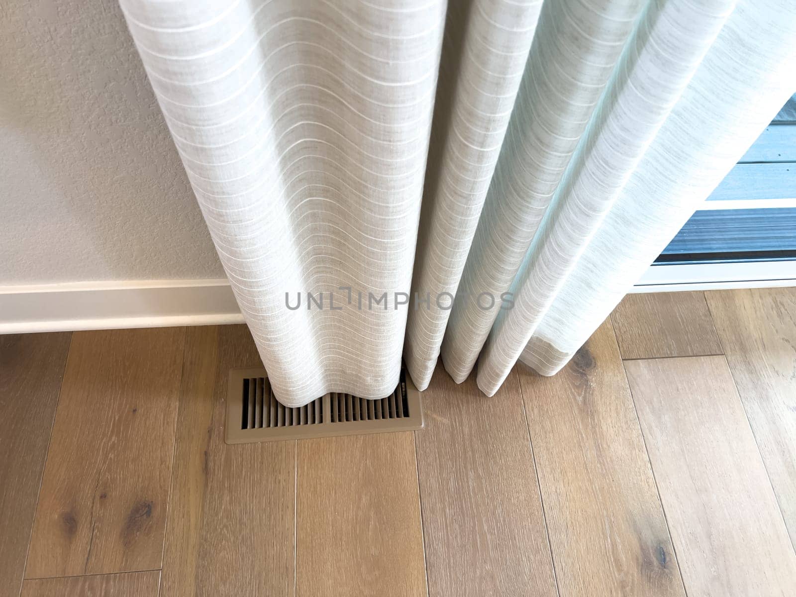 Full curtain fall detail, softly draped over vent on light wood flooring, offering inspiration for light-filtering drapes and interior styling visuals.