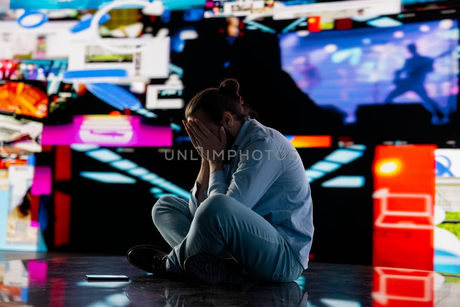 Paranoid guy suffers from emotional damage caused by obsessive social media use. Young man being overwhelmed by excessive information and comparison affecting his self esteem, manipulation.