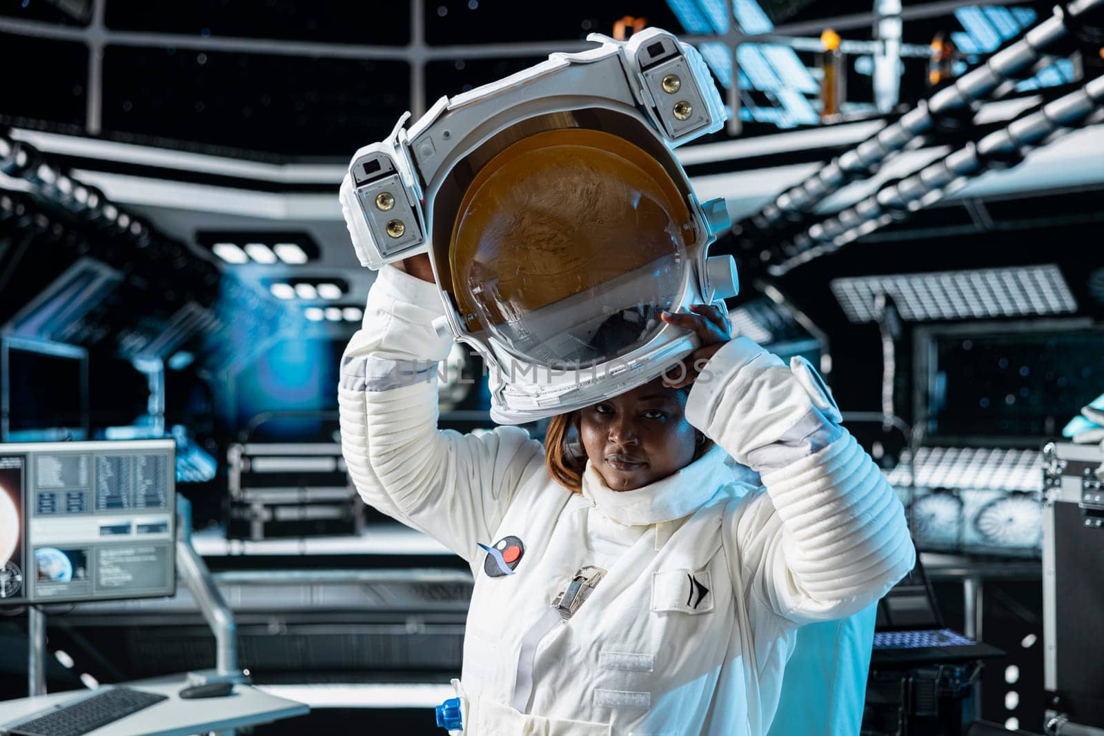 Portrait of female cosmonaut putting on cosmic gear helmet, preparing for planetary mission outside. African american woman in orbital station beginning landing procedures on solar system planet