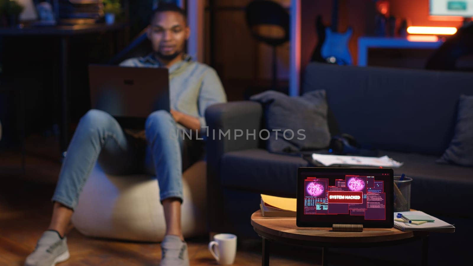 Black IT professional in loft working on cybersecurity with gadgets, tackling hacking attempts, encryption and cyber defense. Screen shows security breach warning, data security risks. Camera B.