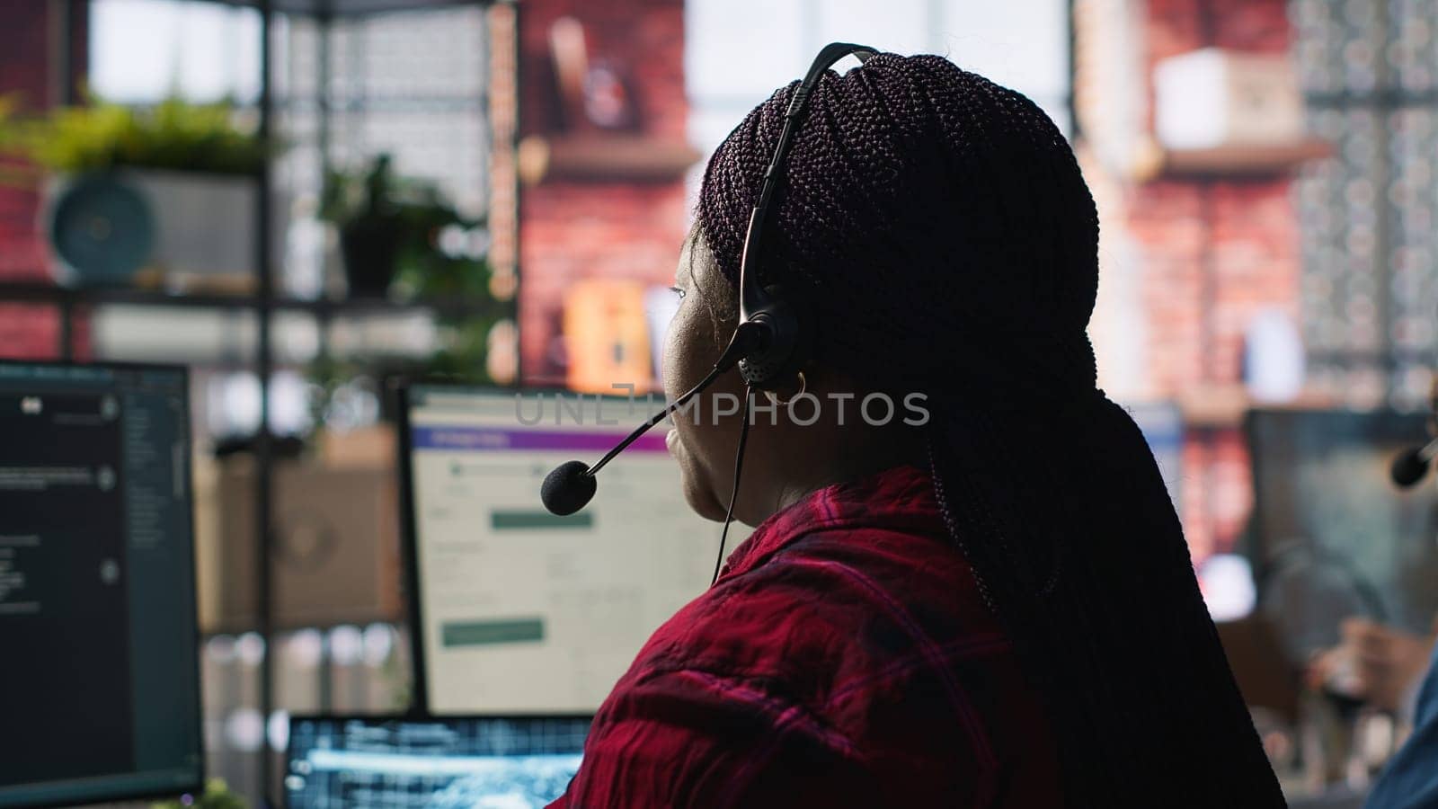 Call center worker in office using AI chatbot to provide quick replies to common customer queries. Woman doing customer service job generating automated responses to clients using AI, camera A