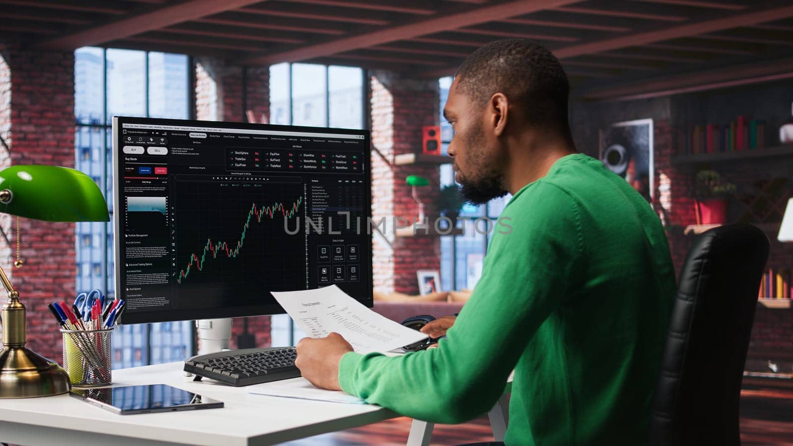 Day trader uses computer to purchase stocks that might perform well and selling ones that might drop in value. Forex trader browsing though stock exchange portfolio pages at PC desk. Camera B.