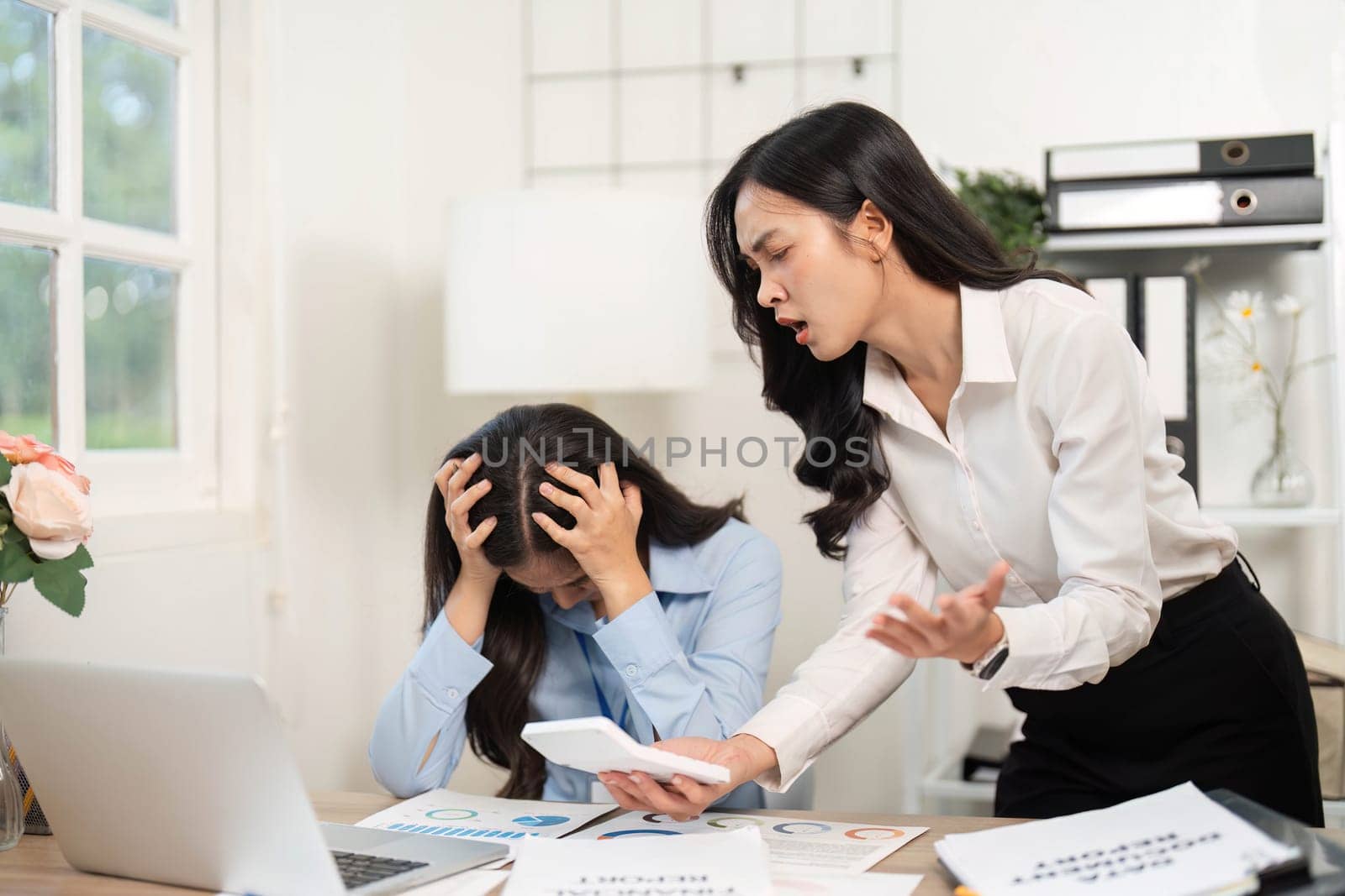 A tense moment in the office as one employee confronts another, highlighting workplace stress and communication issues.