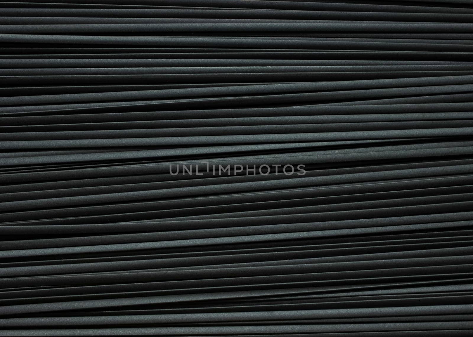 Monochrome striped background of black spaghetti pasta. High quality photo