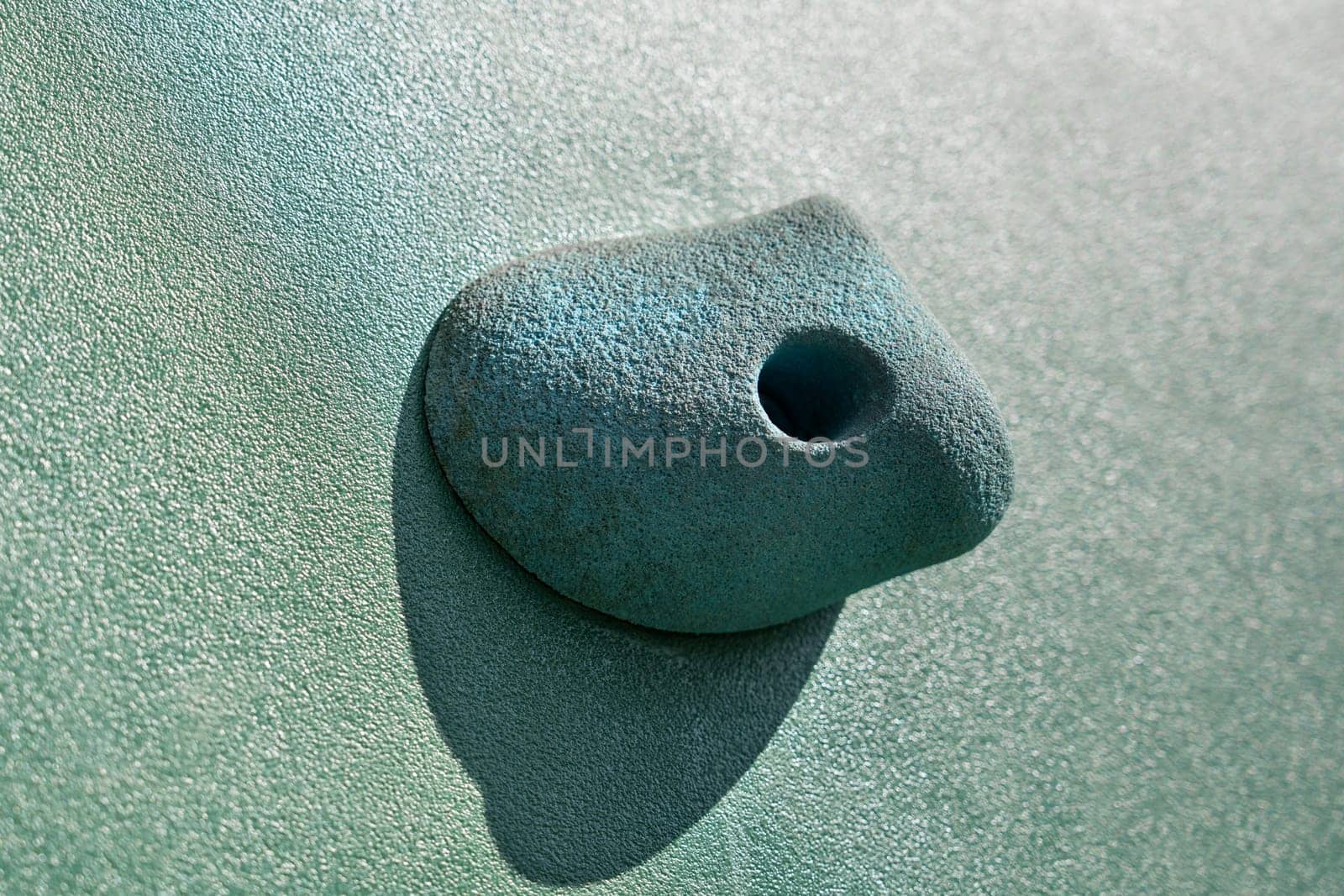 An artificial blue climbing hold on a wall. Close up macro