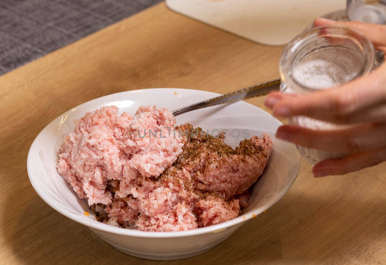 Just ground meat mince in the glass bawl of the electrical chopper on the kitchen counter top being seasoned and mixed. Cooking