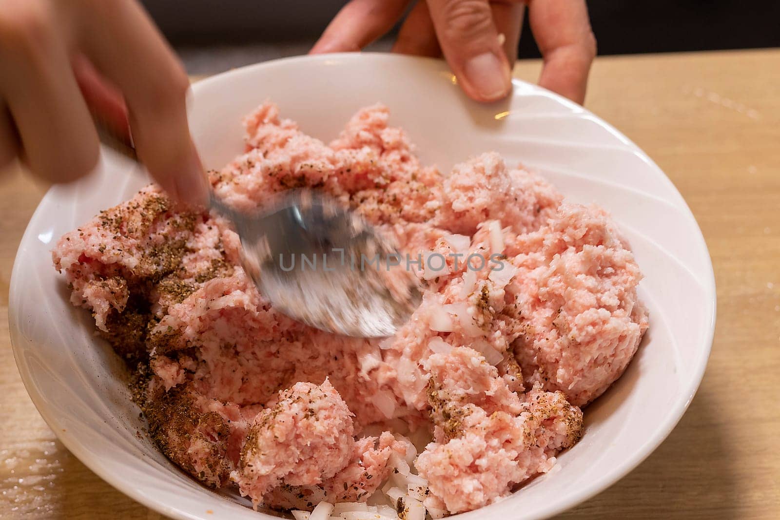 Just ground meat mince in the glass bawl of the electrical chopper on the kitchen counter top being seasoned and mixed. Cooking