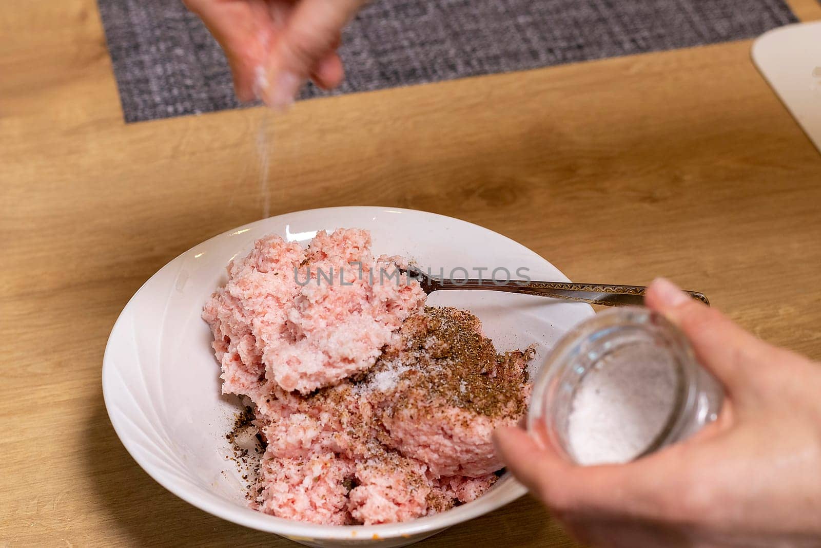 Just ground meat mince in the glass bawl of the electrical chopper on the kitchen counter top being seasoned and mixed. Cooking