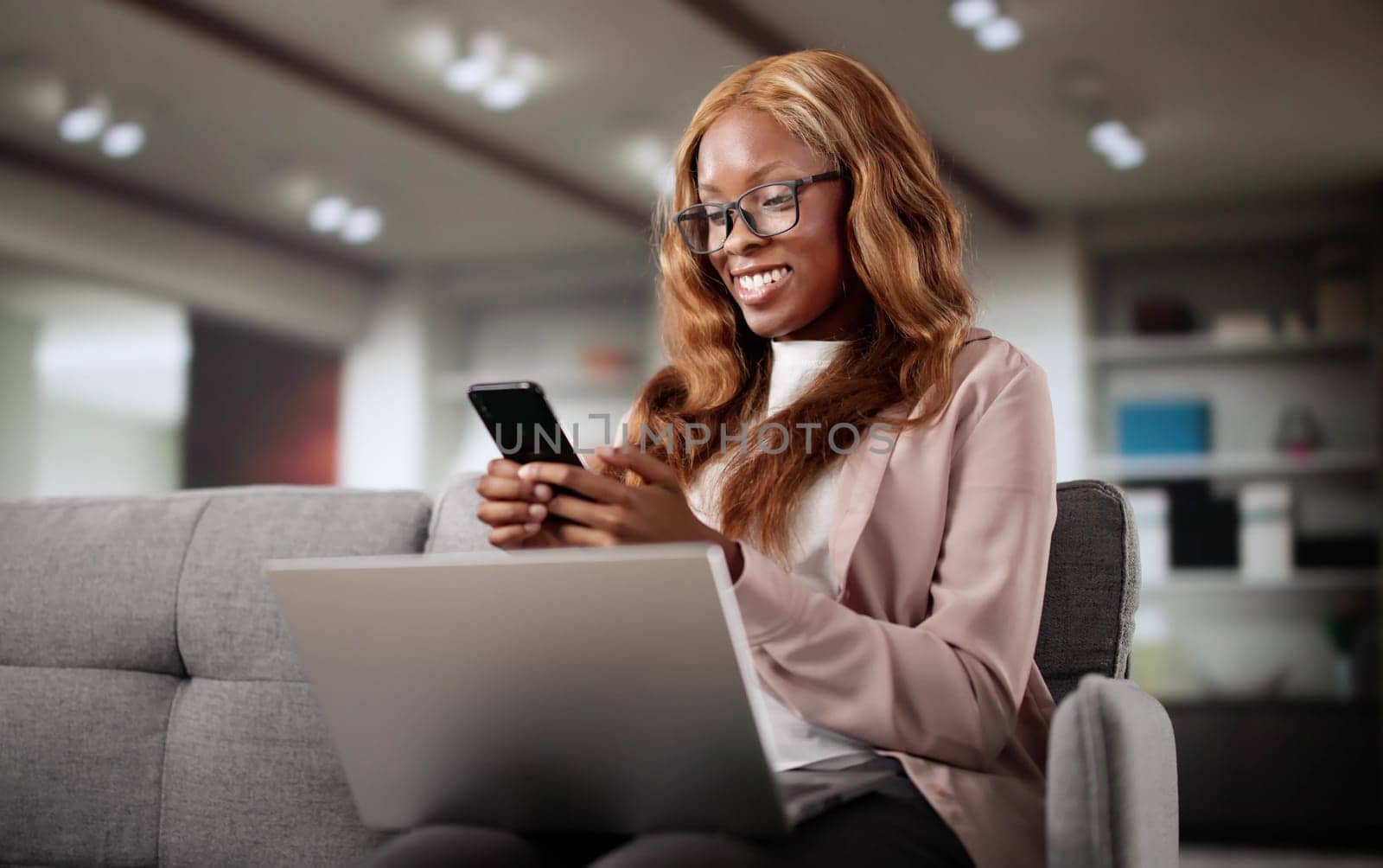 Happy African American Woman Shopping On Laptop In Online Store. Excited Woman Watching Telehealth Video On Smartphone