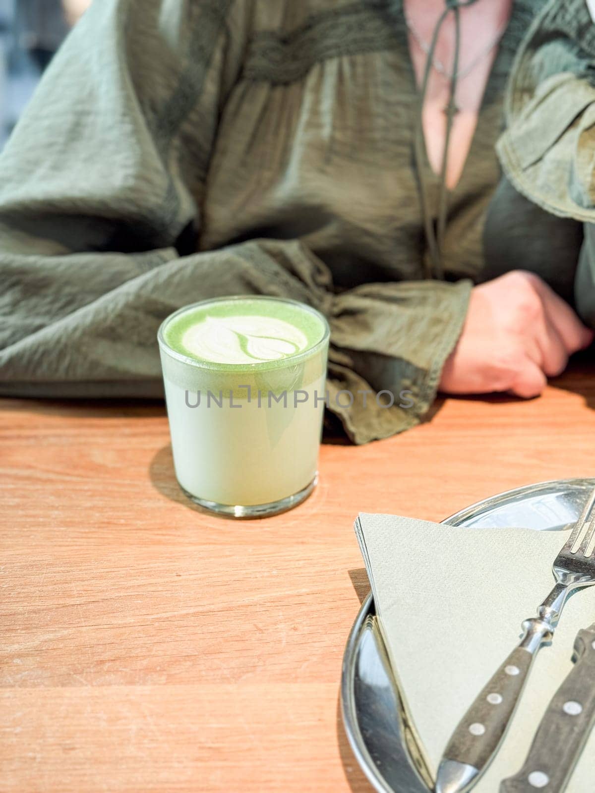 Green matcha latte on wooden table. Drinks, modern lifestyle and coffee shop concept.