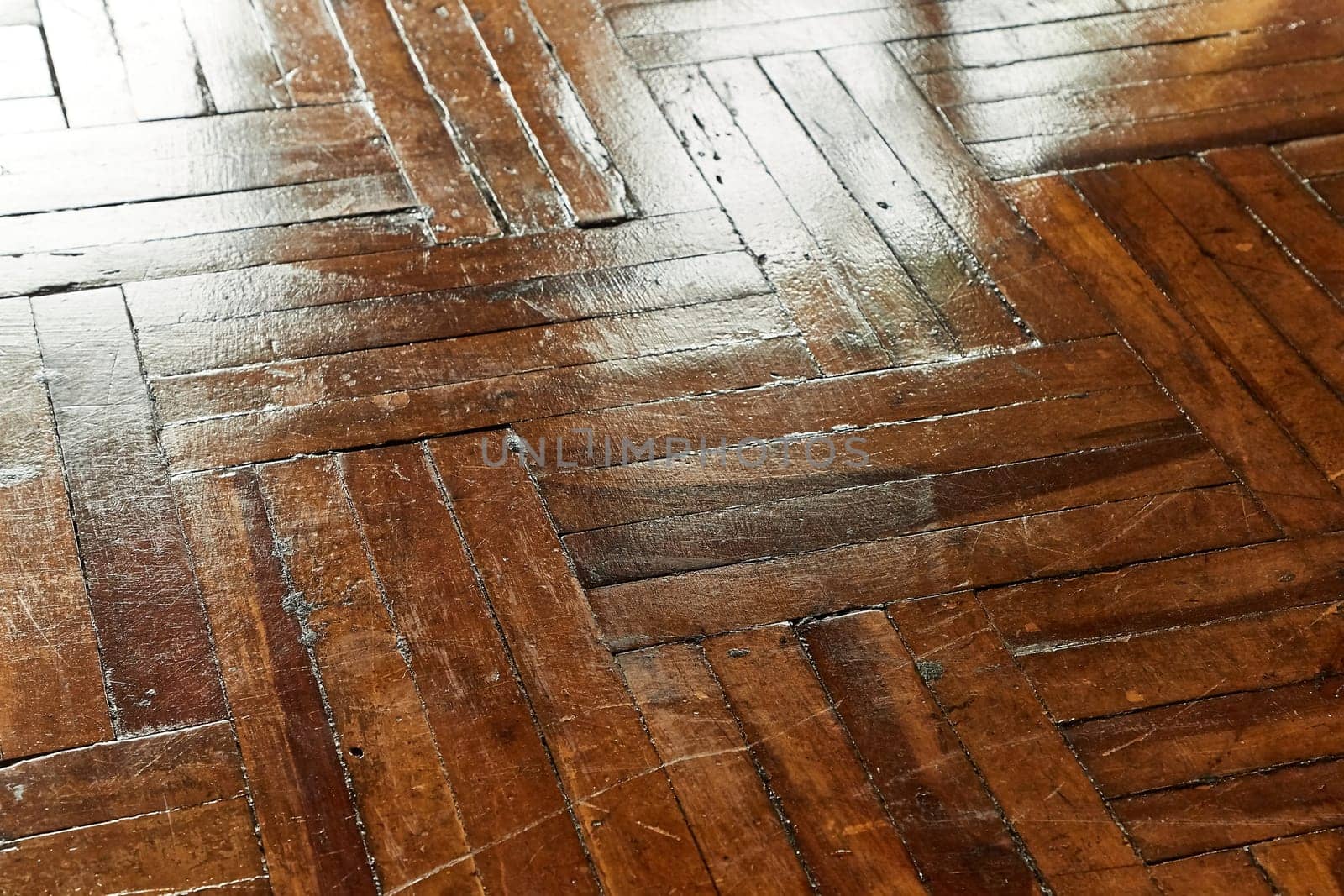 Shiny old dark wooden floor parquet reflecting light