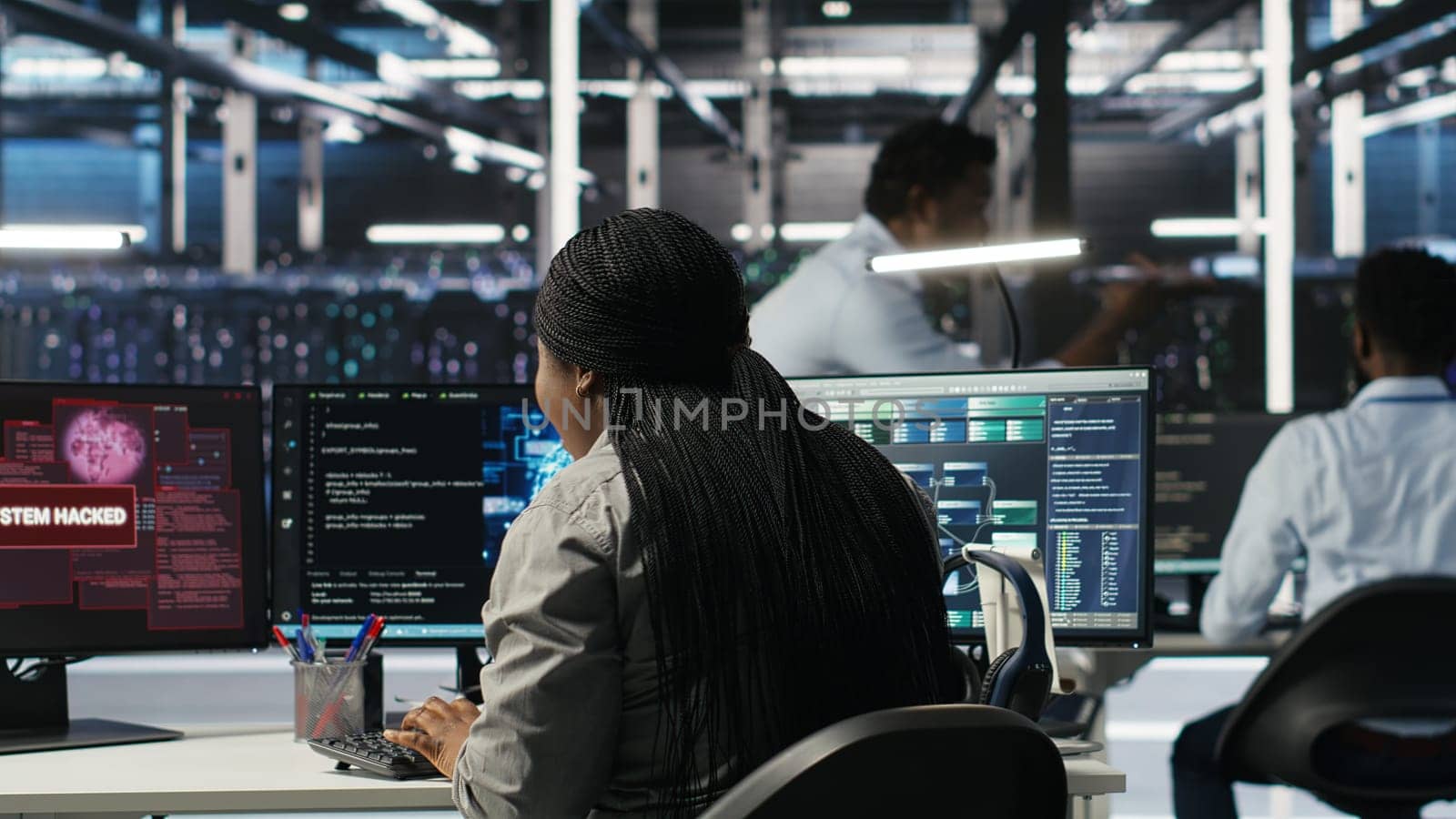 Server hub coworkers react to security breach after unauthorized access bypassing firewall compromising data. Employees initiate emergency response protocols after cybersecurity alert, camera B