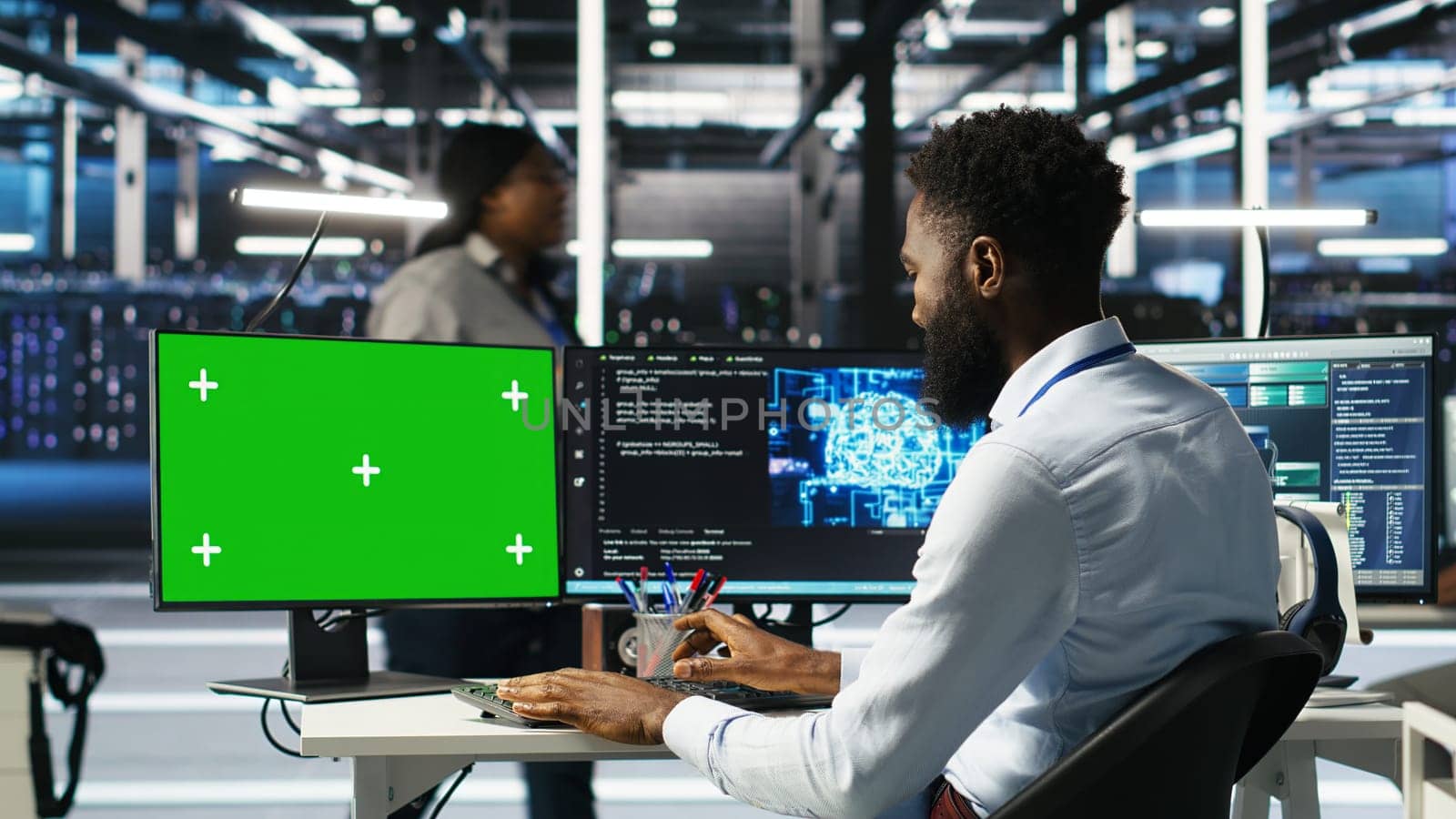 Data center admin using AI node tree software on isolated screen PC to minimize system downtime. Server hub worker uses artificial intelligence visual programming tool on chroma key computer, camera B