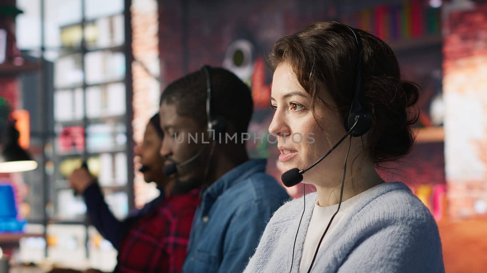 Call center agent handling inbound calls, assisting customers with inquiries, updating account records and meeting performance metrics in office environment, camera A close up