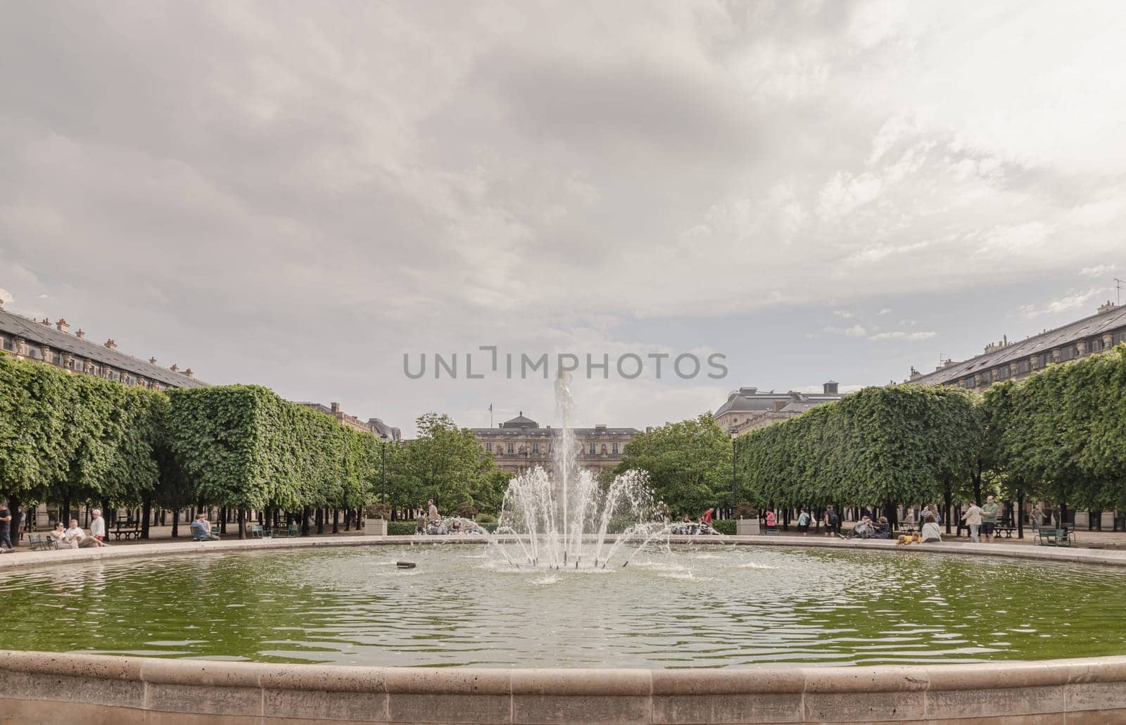 France, Paris - May 03, 2025 - View of Fountain in the Jardin du Palais Royal with the Palais Royal building and sky in the backhground. known as "Fontaines de Pol Bury" use it as your Wallpaper, Poster and Space for text, Selective focus.