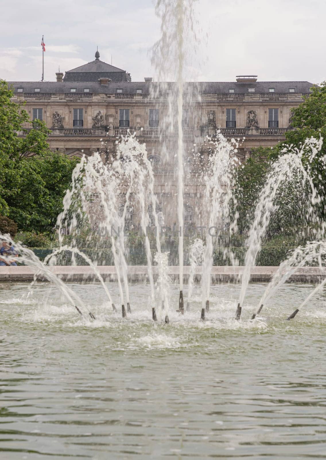 France, Paris - May 03, 2025 - View of Fountain in the Jardin du Palais Royal with the Palais Royal building and sky in the backhground. known as "Fontaines de Pol Bury" use it as your Wallpaper, Poster and Copy space, Selective focus.