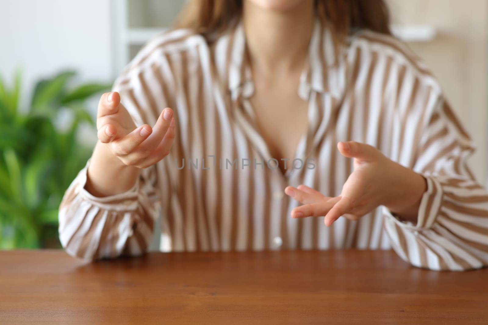 Front view close up portrait of a woman hands gesturing while is talking at home