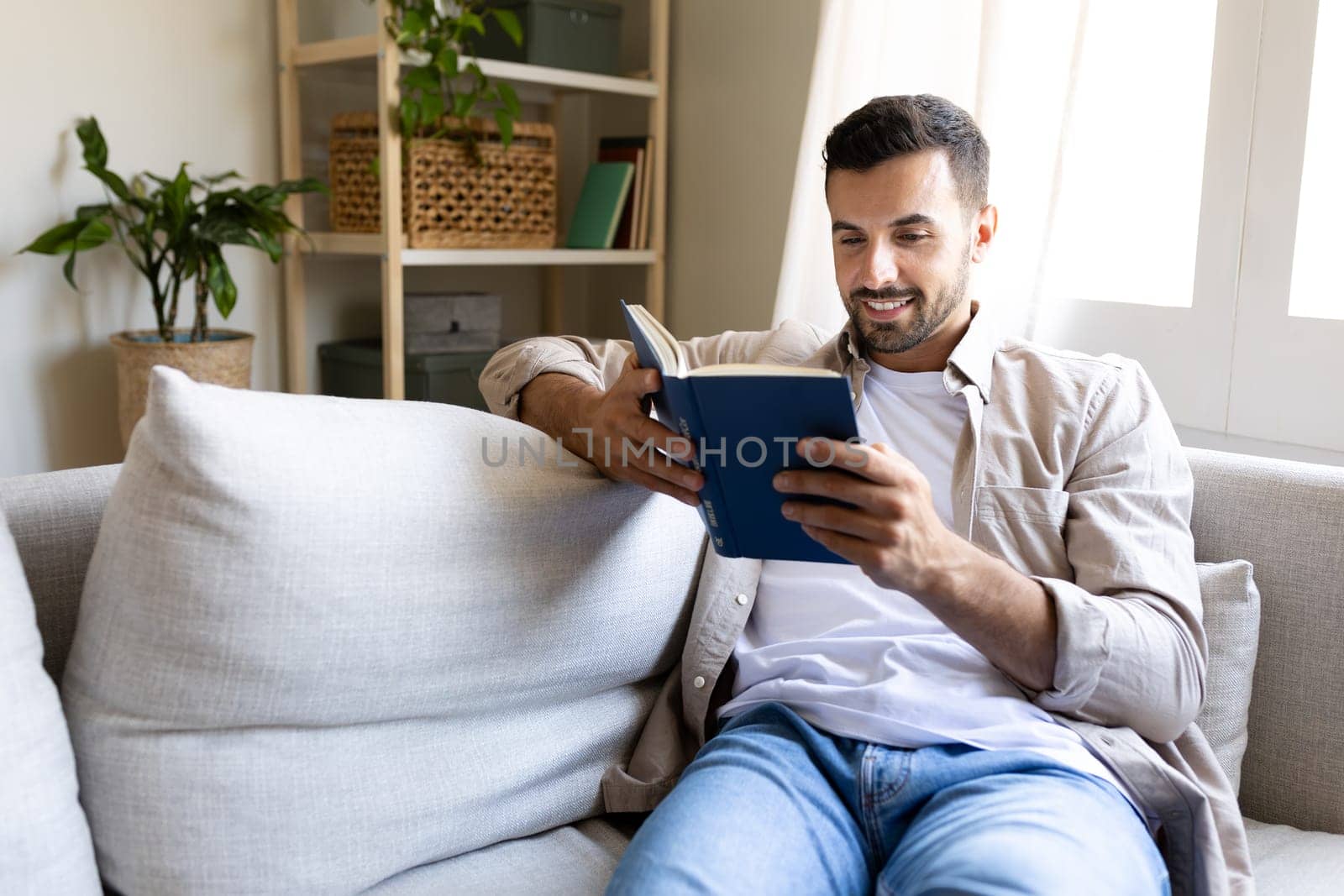 Happy man relaxing at home reading a book.Copy space. Lifestyle concept.