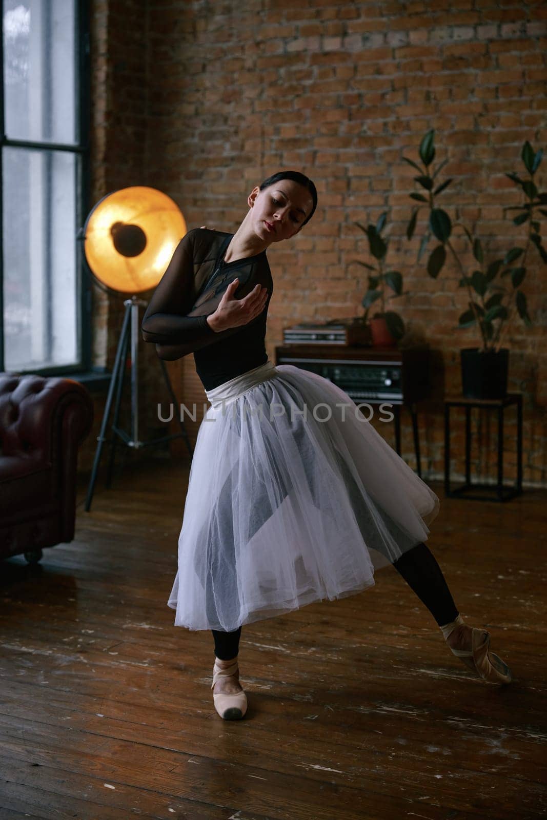A graceful ballet dancer in a flowing tulle skirt elegantly strikes a stunning pose in a chic urban setting