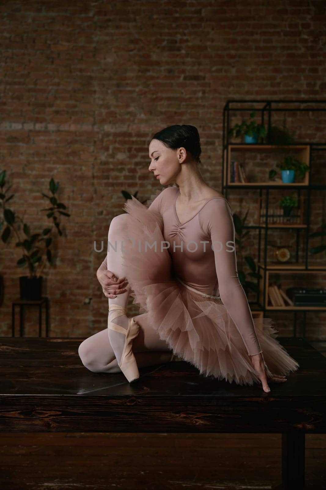 A stunning ballet dancer elegantly showcases her impressive technique in a stylish and artistic indoor space