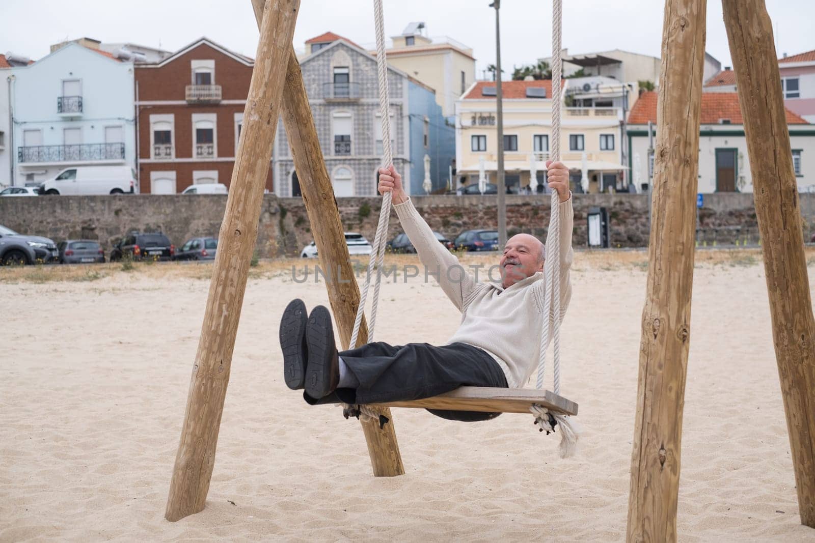 An hispanic elderly person swinging on a swing, reminiscing about childhood.