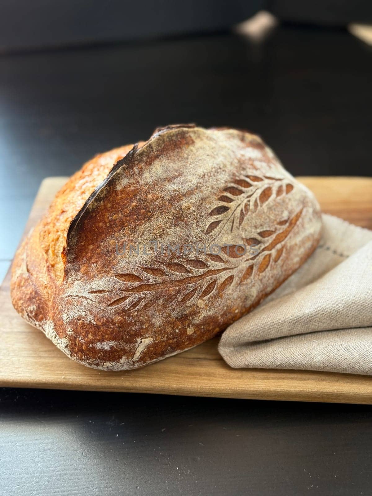 close view of a freshly baked sourdough bread with a textured, golden crust. High quality photo