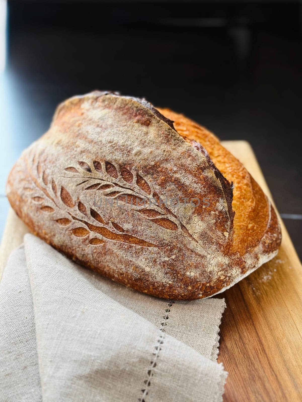 close view of a freshly baked sourdough bread with a textured, golden crust. High quality photo