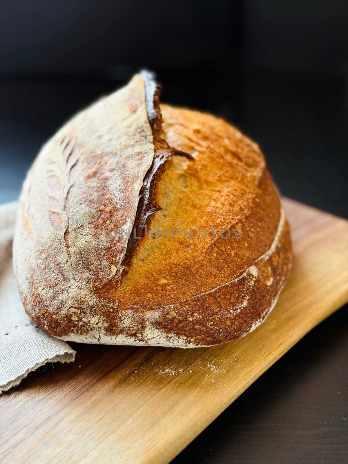 close view of a freshly baked sourdough bread with a textured, golden crust. High quality photo