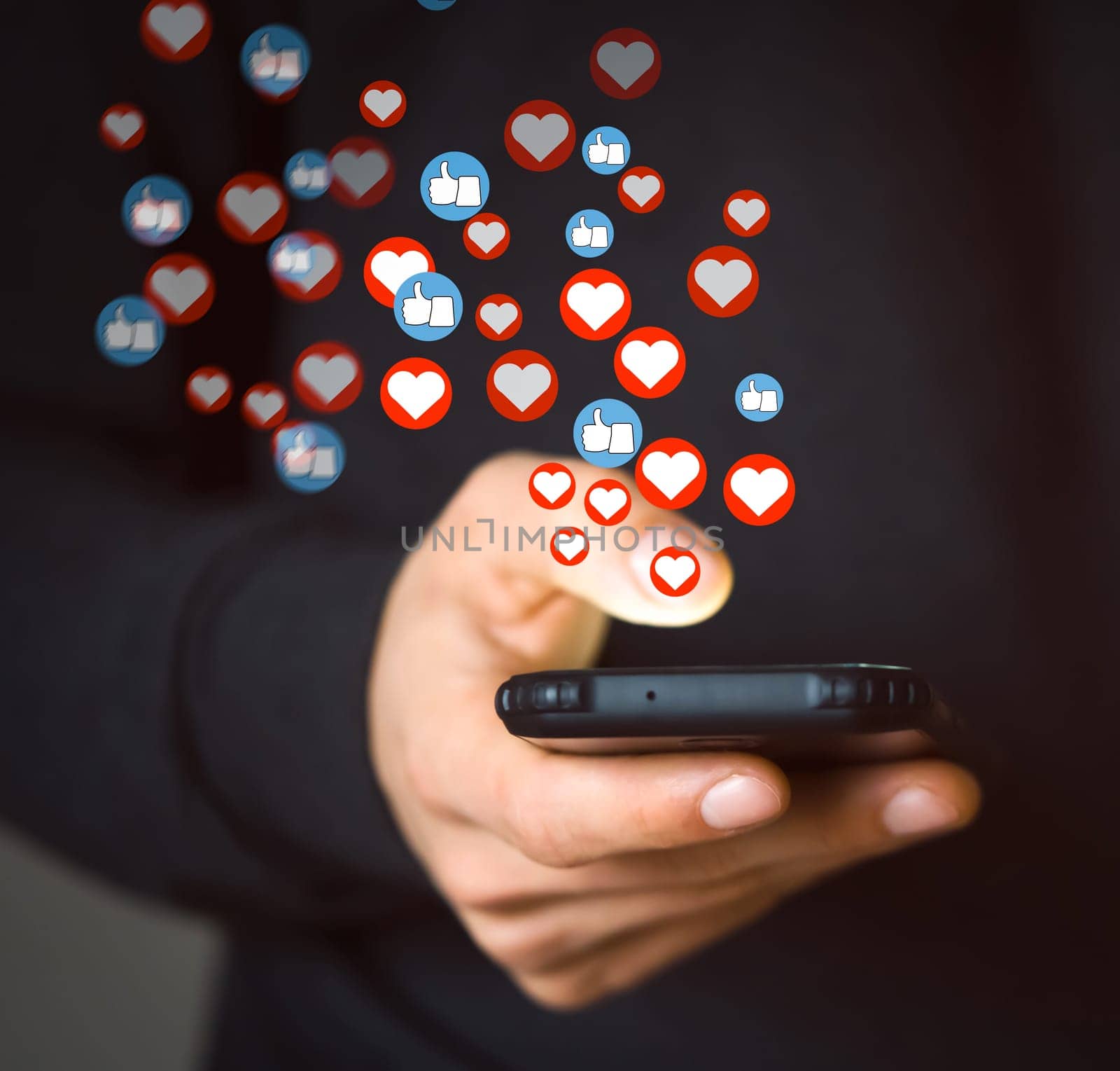A young man holds a mobile phone in his hand and bank card, writes a positive review with likes and hearts or makes donate, uses social networks and does shopping, makes purchases with online banking.