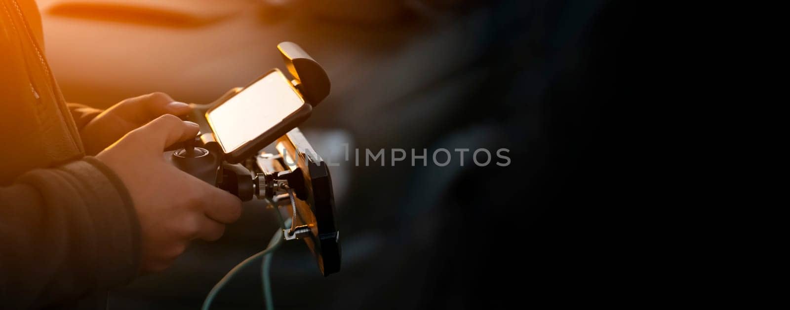 A man holds a remote control in his hands and controls a UAV flight, a drone or an aircraft with a powerful antenna, a man is involved in the development of technologies, does a security mission.
