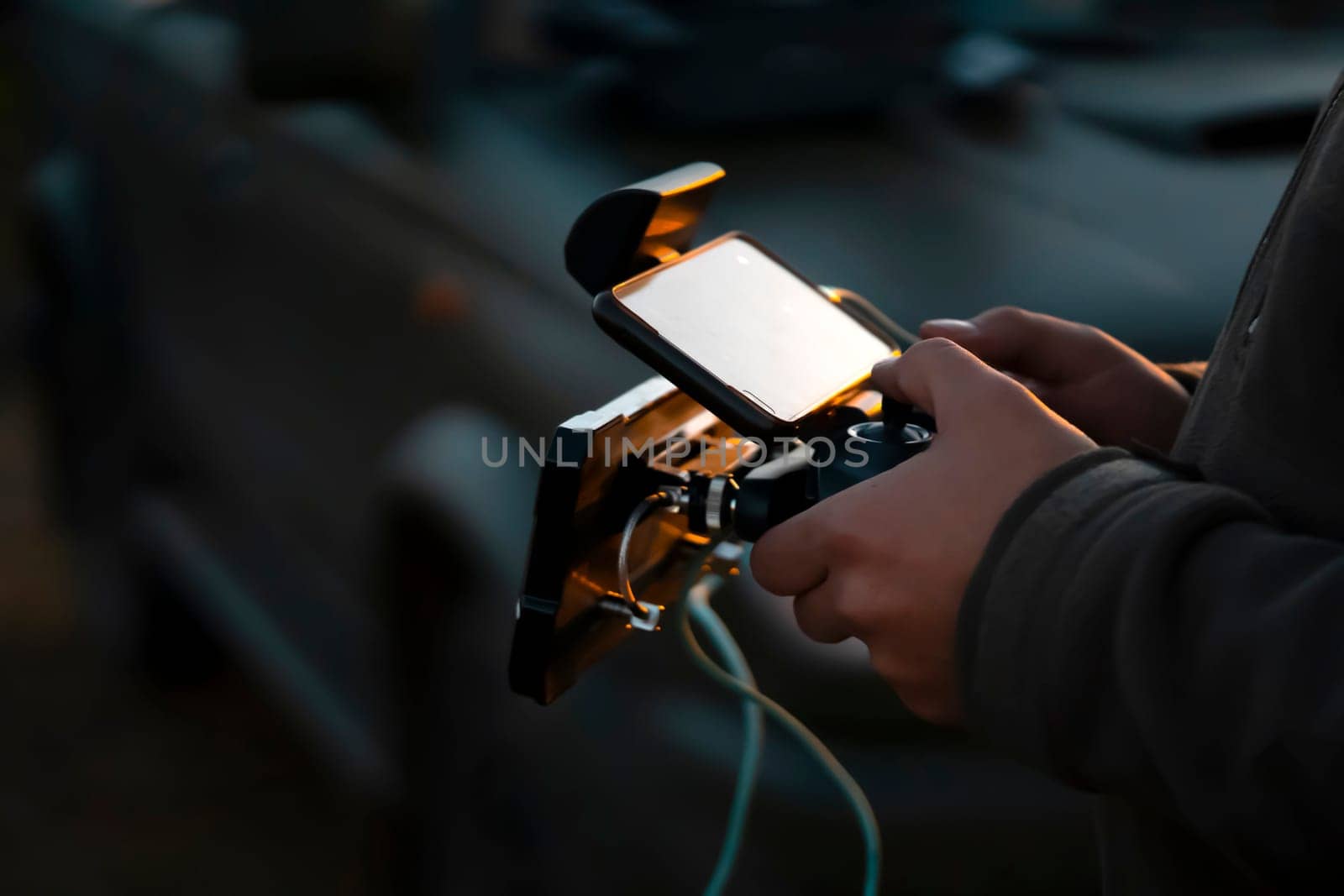 A man holds a remote control in his hands and controls a UAV flight, a drone or an aircraft with a powerful antenna, a man is involved in the development of technologies, does a security mission.