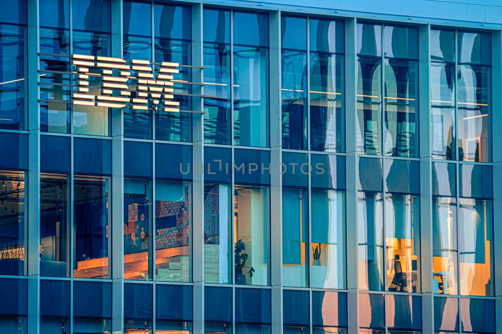 Jan 16, 2025 - Lisbon, Portugal: Day view of IBM office building with glowing logo and sleek glass exterior. Illuminated interior spaces and reflections, innovative spirit and global presence of renowned technology corporation, corporate life
