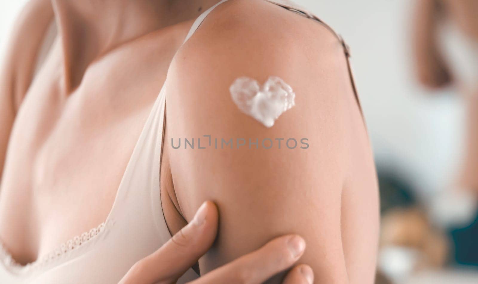 A young girl applies a moisturizer to her skin, a woman gently cares for her body, depicts a heart with a cream, taking care of herself, beauty and health.