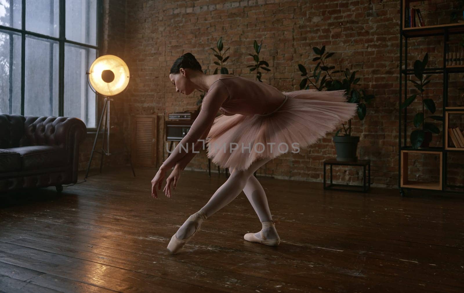 A graceful ballet dancer exhibiting elegance and poise within a peaceful, beautifully lit studio environment