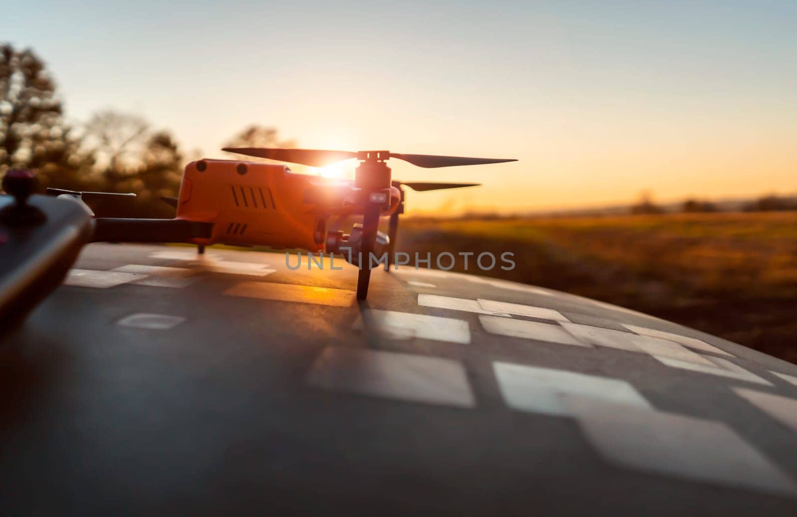 A drone and remote control against the sunset outdoors, in the rays of the sun. UAV technologies for monitoring territories, secret missions from the air, agricultural purposes and security.