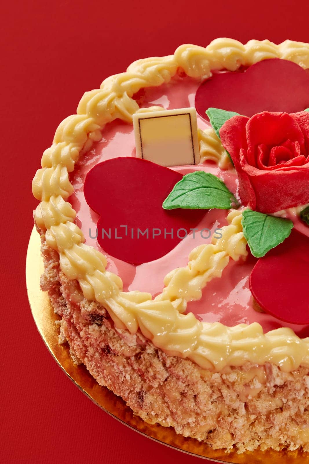 Pink cake with heart shapes, rose and whipped cream decoration, for braun family celebrating on red background