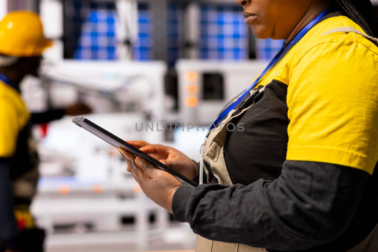African american engineer develops automated workflows using tablet, optimizing smart factory machinery through digital automation interface. Industry 4.0 expert enhances industrial manufacturing.