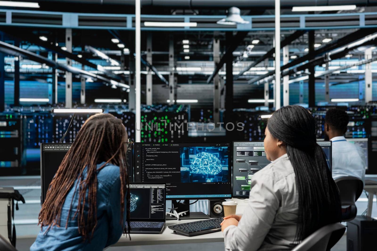 Data center engineering team working together, using AI visualization to oversee automated repetitive tasks. Server farm teamworking colleagues modifying systems based on data analytics graphs