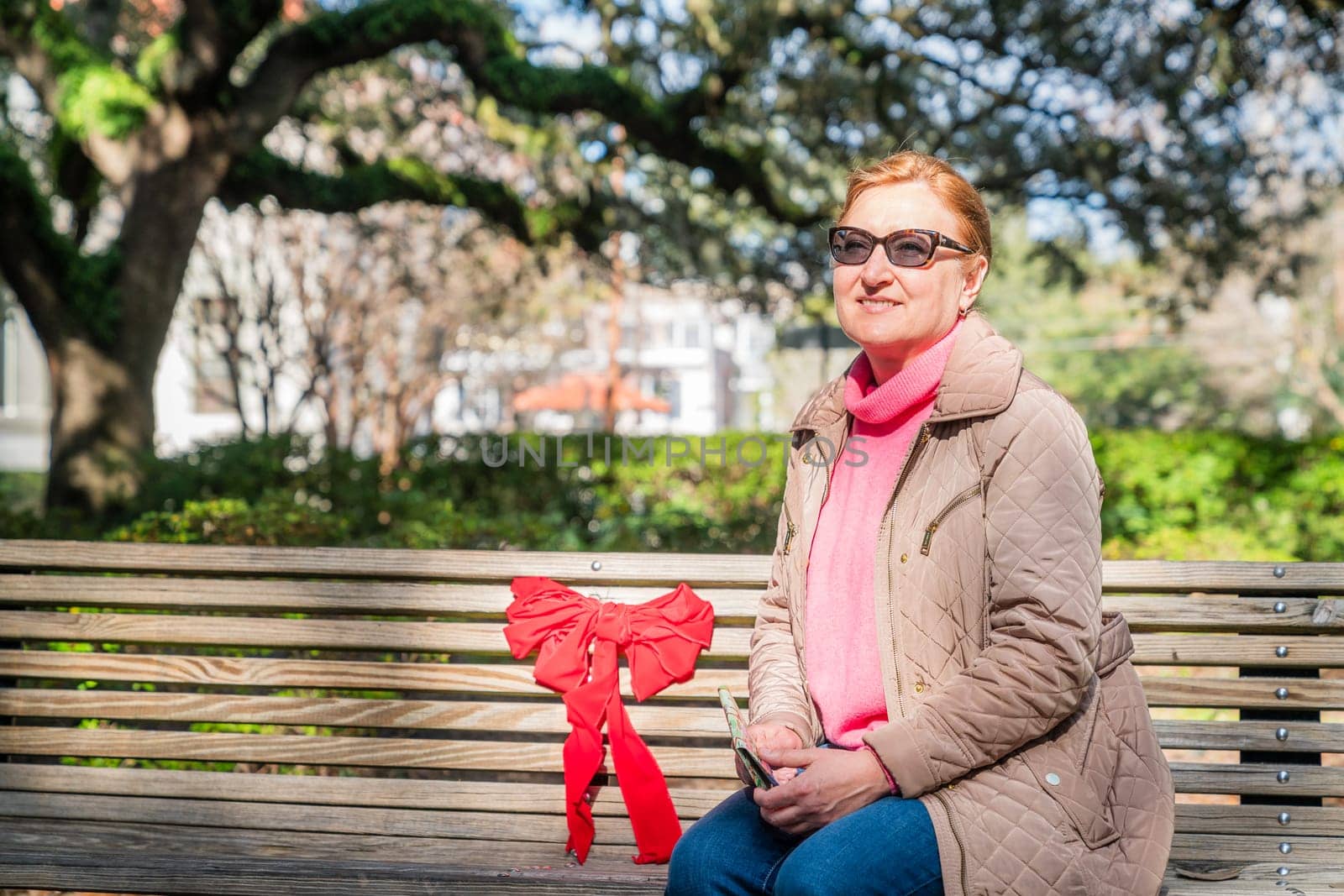 A beautiful mature woman sitting on a bench in a city park in Savannah, Georgia