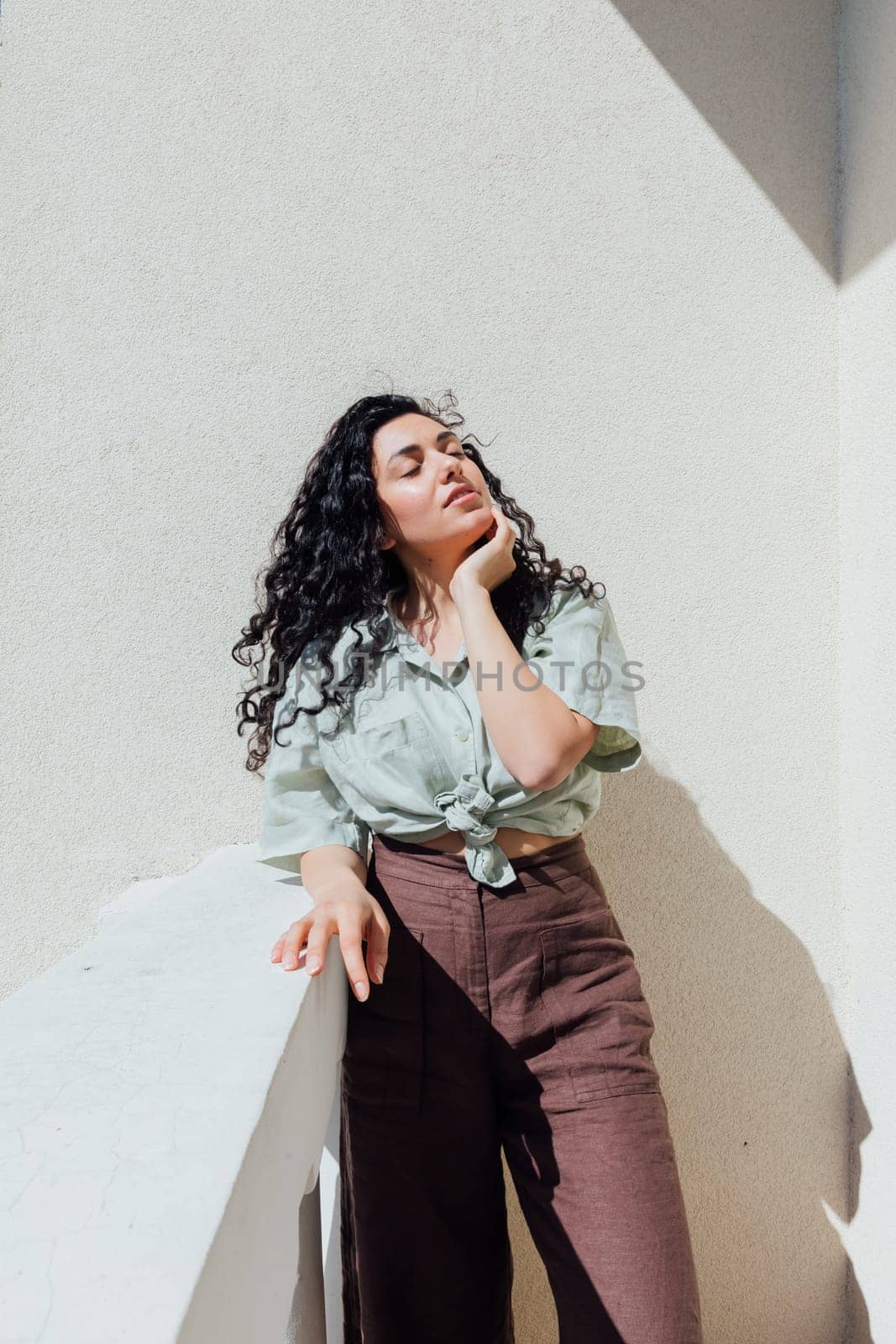 Portrait of a beautiful curly brunette woman in summer clothes