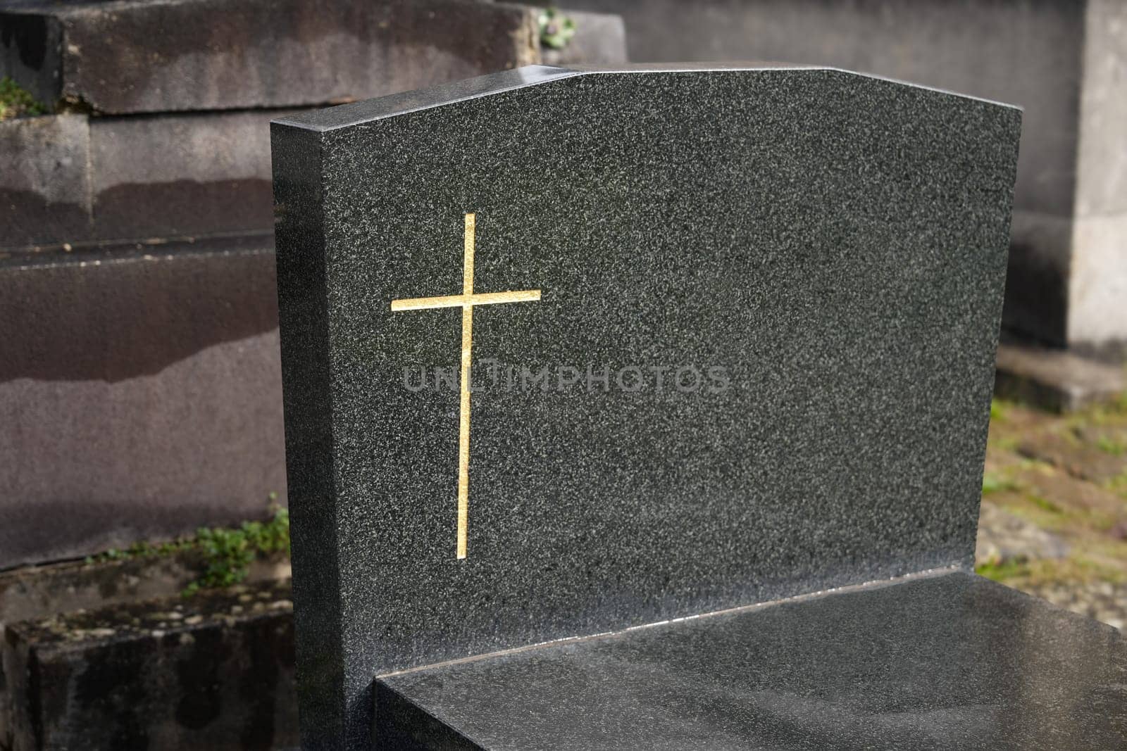 Cross on a marble slab on a grave in a cemetery