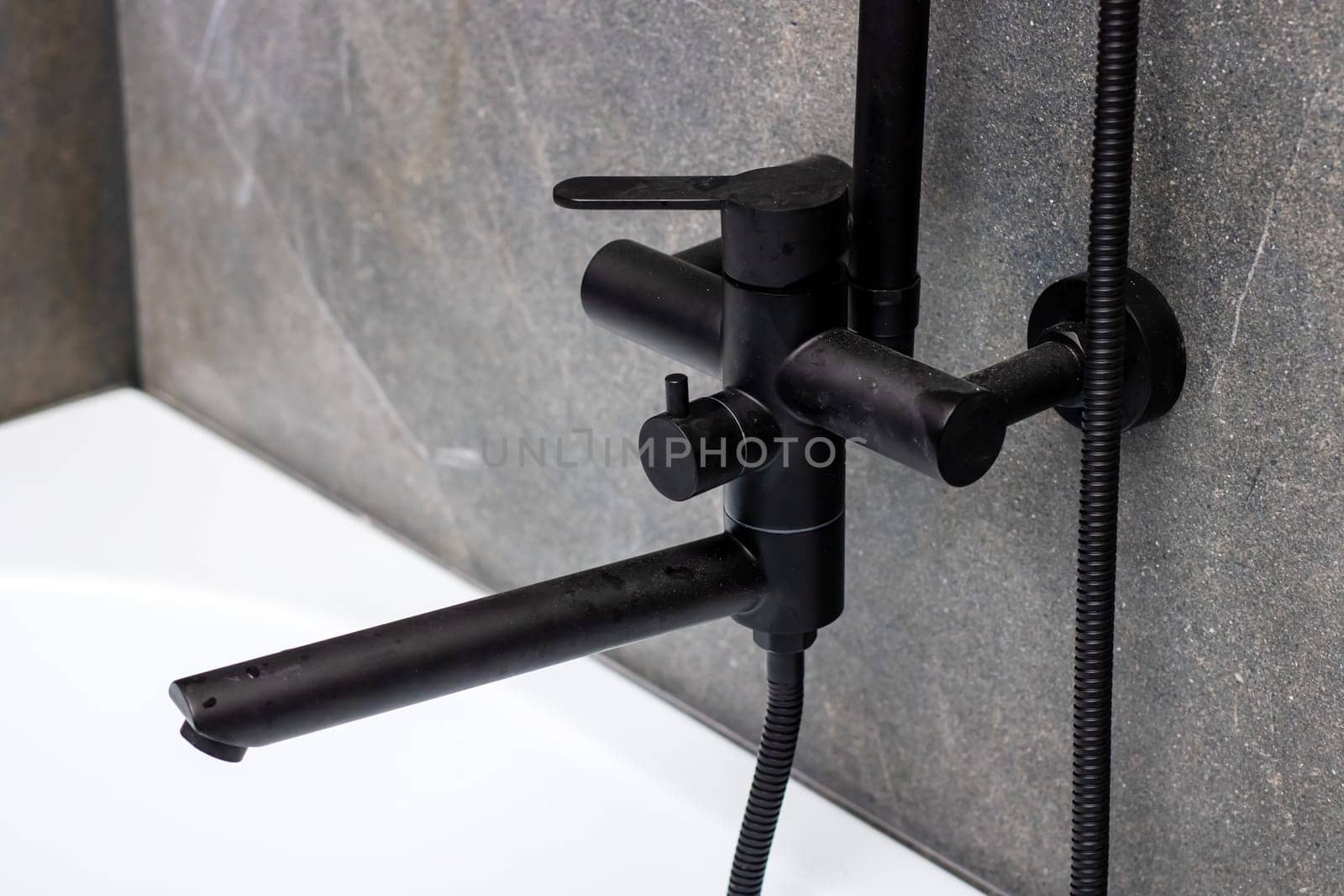 A sleek black faucet featuring a durable hose meticulously attached to it for added convenience and functionality in your kitchen or bathroom