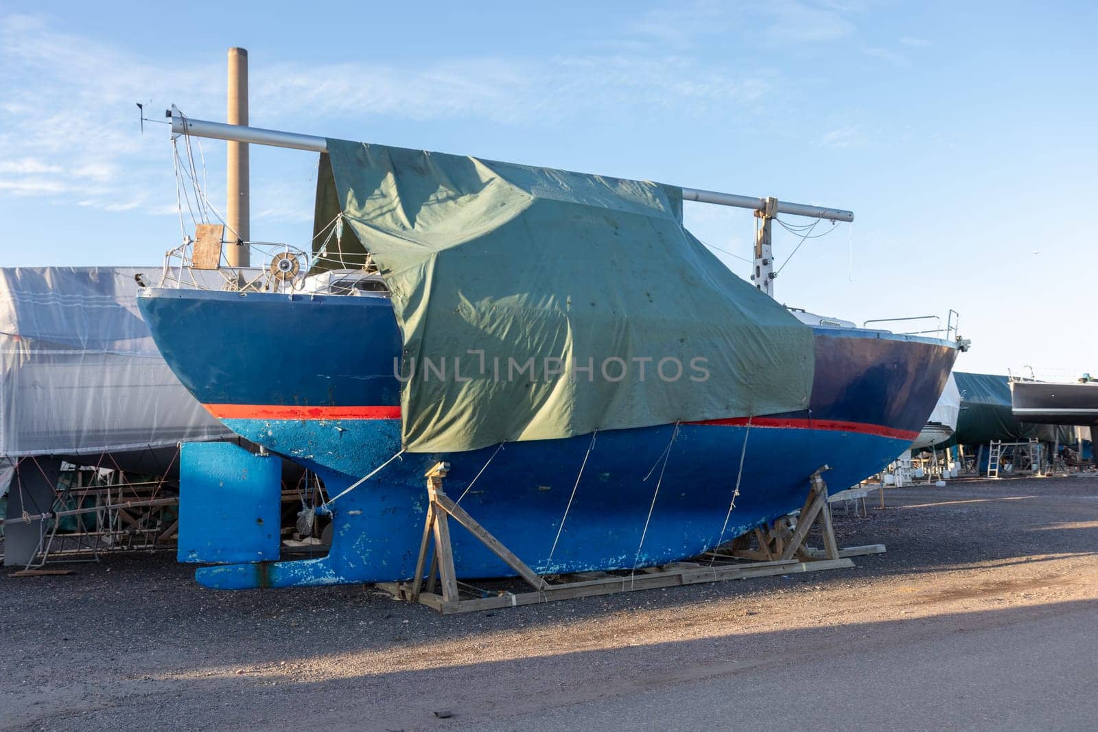 Sailboat covered and stored out of the water for the winter, winter storage for the sailboat in Finland, Suomenoja, winterizing , short season in Northern country, cold conditions