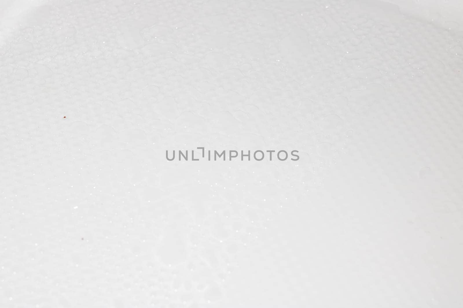 A closeup view of a predominantly white surface that is adorned with numerous small dots scattered across its entirety