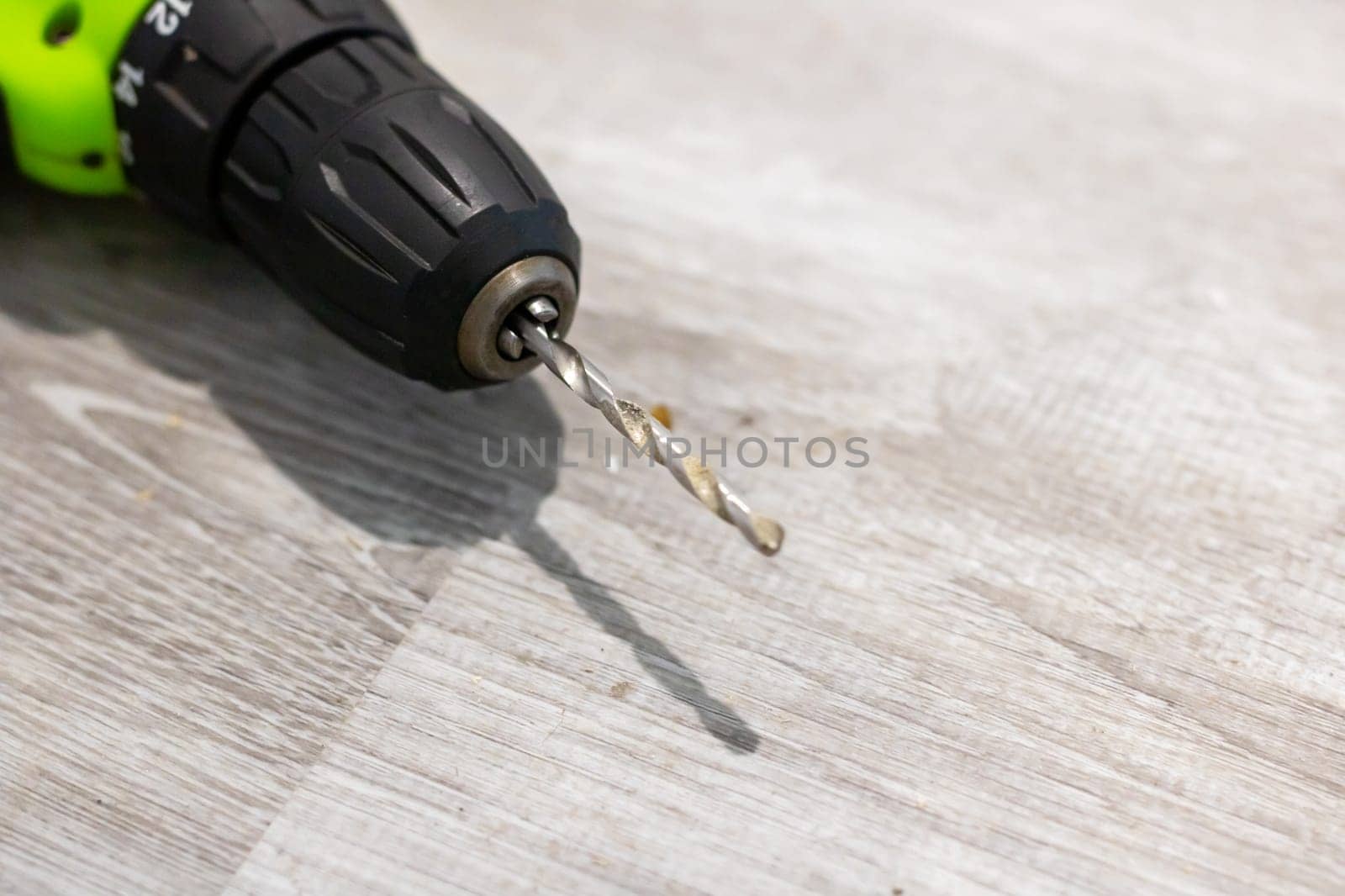 This is a closeup view of a drill bit resting on a wooden surface, showcasing its fine details and design intricacies