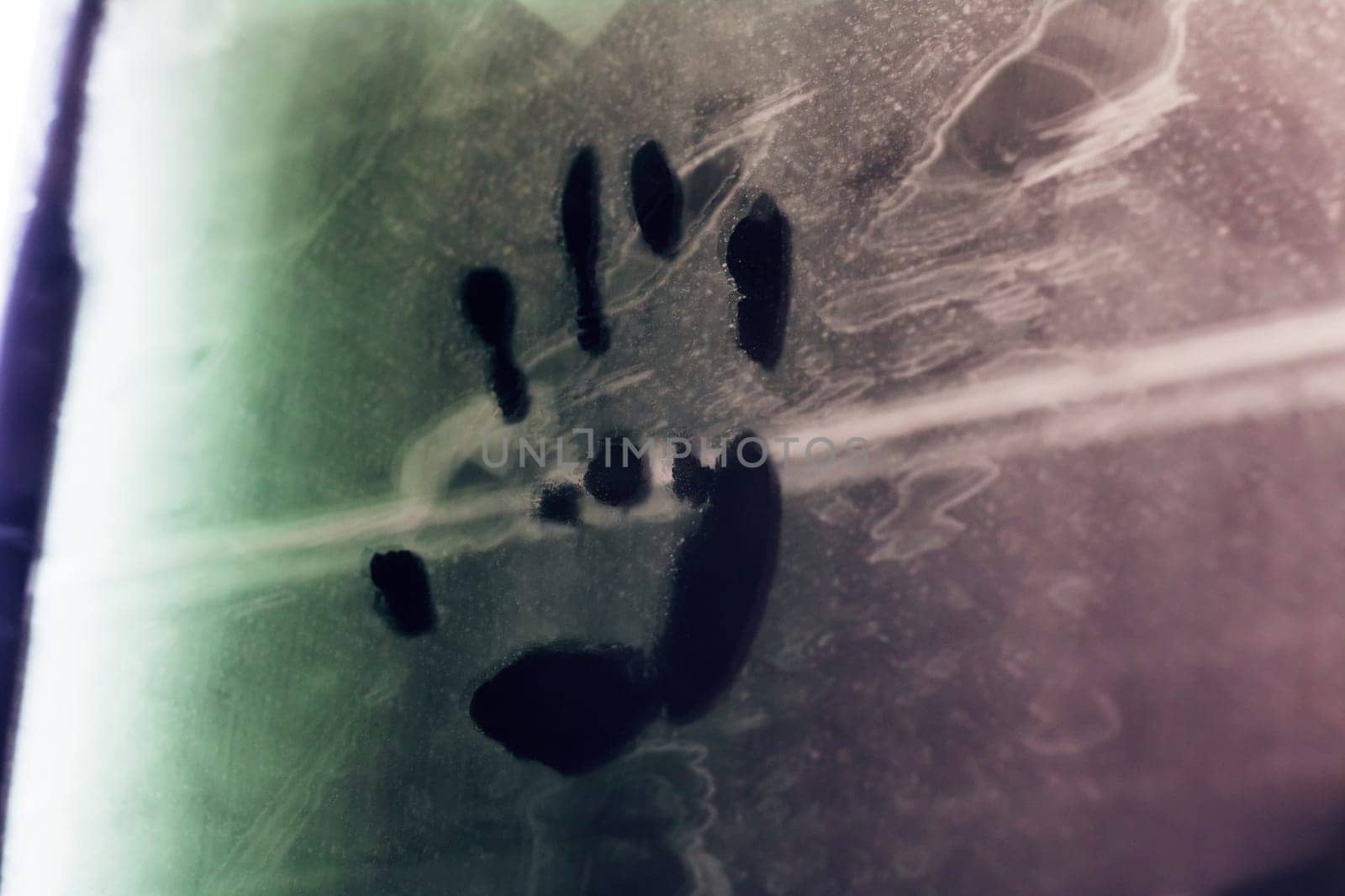 A distinctive hand print stands out prominently against an artistic backdrop featuring vibrant green and deep purple hues