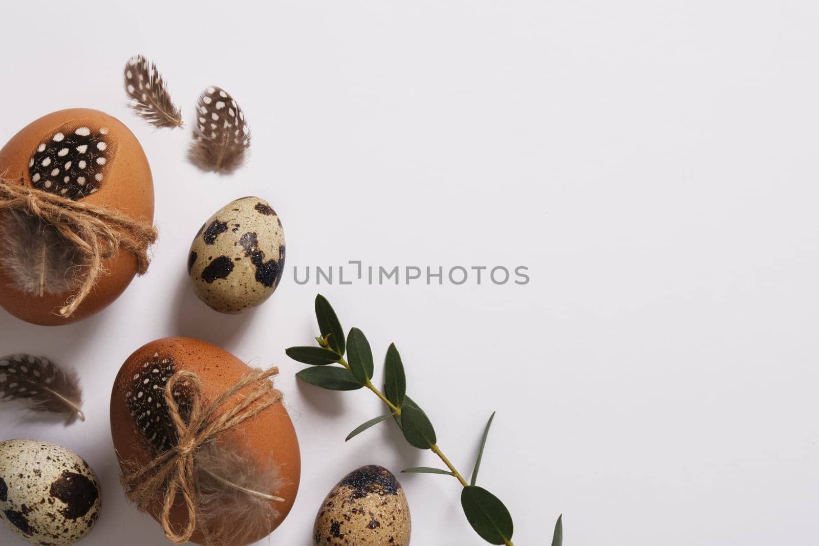 Easter eggs decorated with feathers and twine. Space for your text.