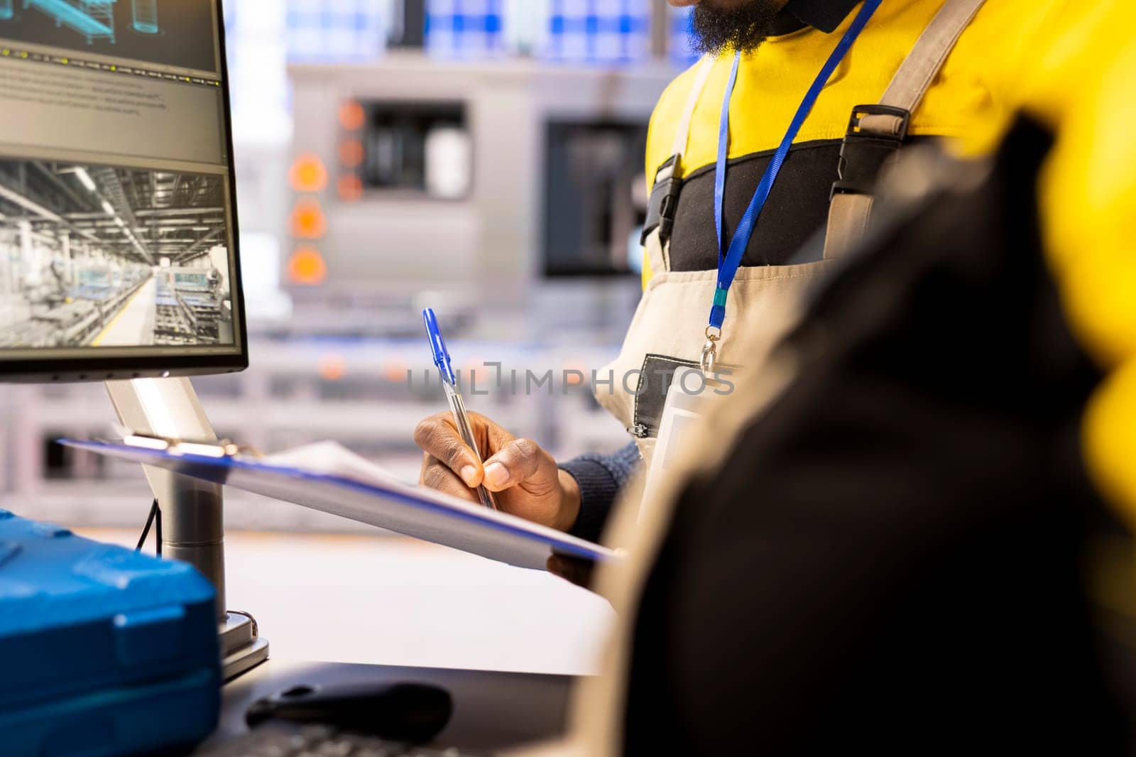 Closeup of professional engineer controlling industrial automation system. Smart manufacturing plant integrates digital technology, robotic arms and automated conveyor belts for streamlined production